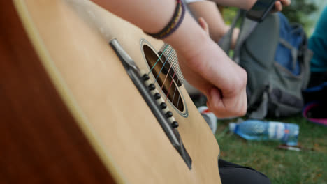 a close-up of a person playing the guitar on a mountain