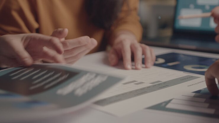 Hands of Colleagues Discussing Business Papers at Office Meeting