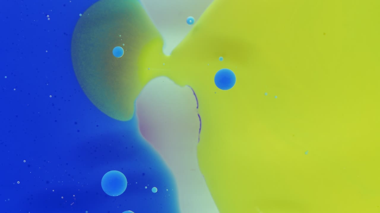 Colorful bubbles. Abstract yellow, blue mixture on a black background. Artistic color paint background.