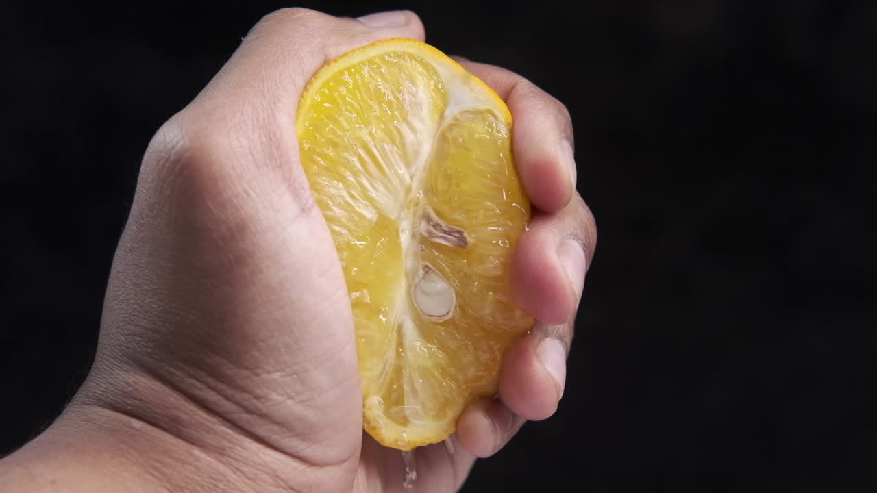 la mano exprimiendo un limón