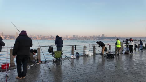 people fishing on a pier with city view