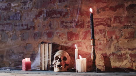 video de una pila de libros con telaraña, cráneo y velas en el fondo de la pared de ladrillo