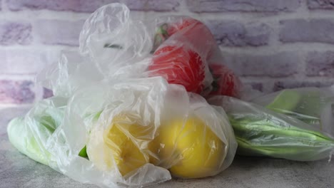 plastic bags filled with lemons, tomatoes, and green beans