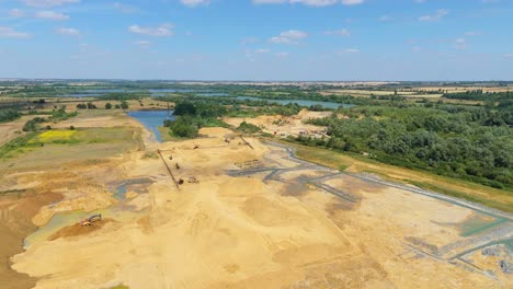 drone aerial view of active quarry site in little paxton england with excavators and diggers working in mineral pit