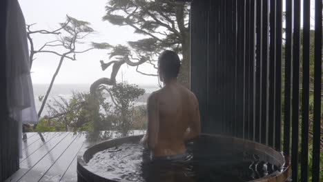 a guy is relaxing on wooden hot tub jacuzzi