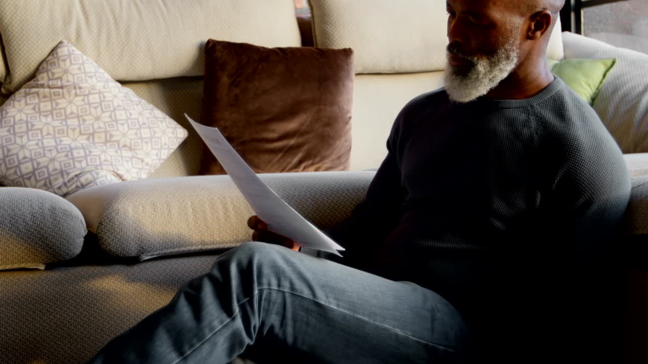 hombre mayor mirando documentos en la sala de estar 4k