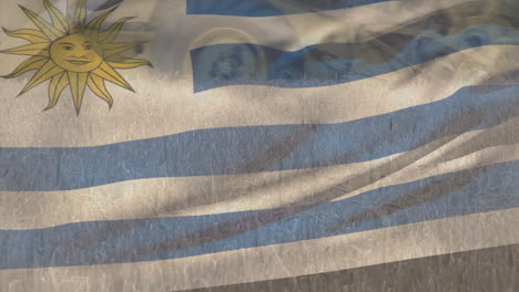 animación de la bandera de uruguay ondeando sobre un campo agrícola