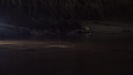 water drop dropping and splashing in the dark bottom of a well, ground-level