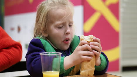 Niño-Comiendo-Hot-Dog-Con-Jugo-De-Naranja