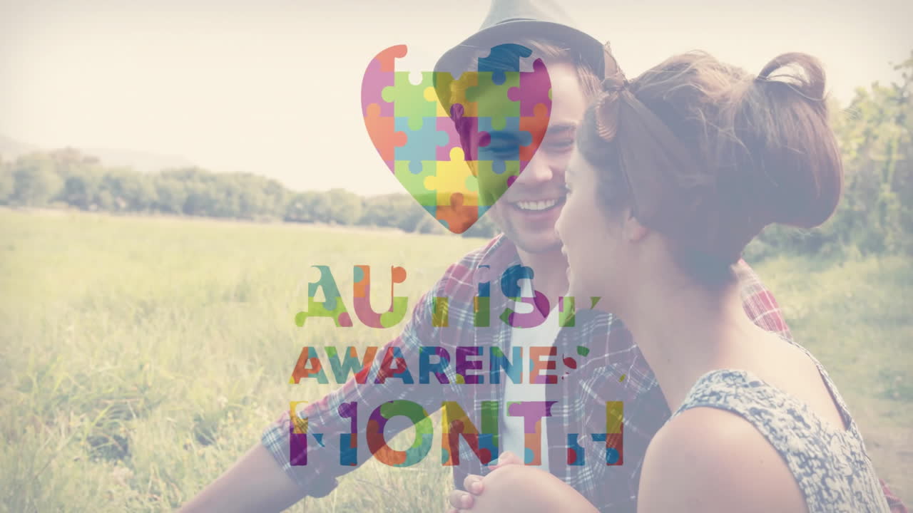 Sitting in field, couple with autism awareness puzzle heart animation overlay