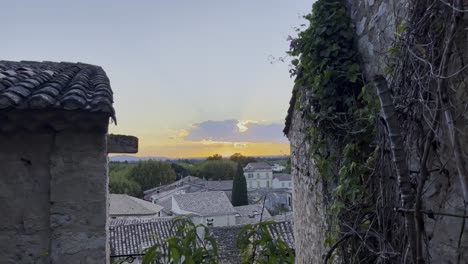 view of a french village between two stone houses on the same level with beautiful historic houses in the village