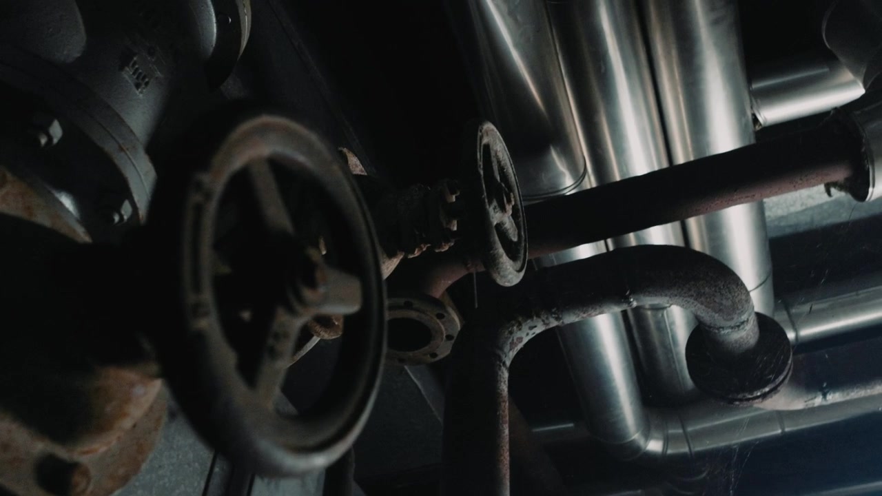 Vecchie valvole arrugginite e tubazioni in una fabbrica industriale abbandonata. Impianto di centrale elettrica.