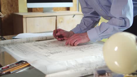 the architect-designer makes notes in pencil on the construction plan