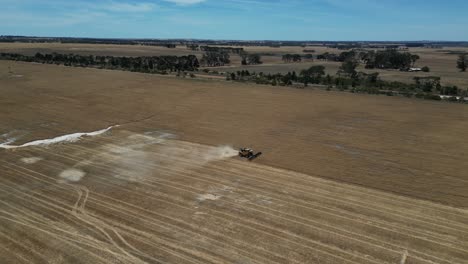 tractor harvesting grain, esperance area in western australia