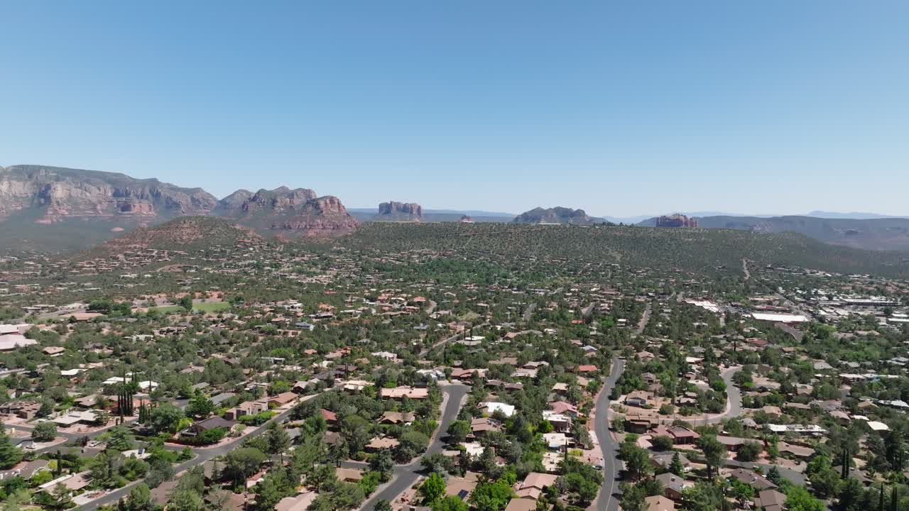 메인 스트리트와 함께 아리조나의 세도나 사막 시의 광범위한 공중  - 푸른 하늘과 함께 은 날 동안 미국 이웃 - 거대한 은 바위 형성이 멀리.