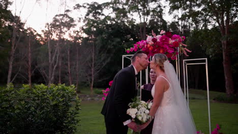 bride and groom share i do and first kiss at floral altar during outdoor sunset wedding ceremony, 4k slow motion