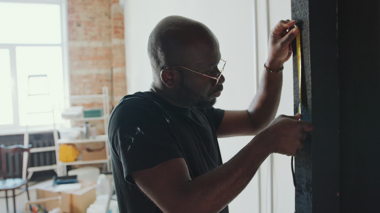 African American Man Measuring Door Frame during Home Remodeling