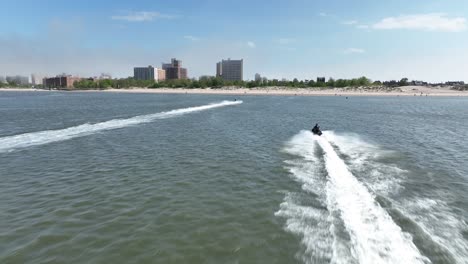 an aerial view over gravesend bay in brooklyn, ny as two jet ski riders enjoys the day