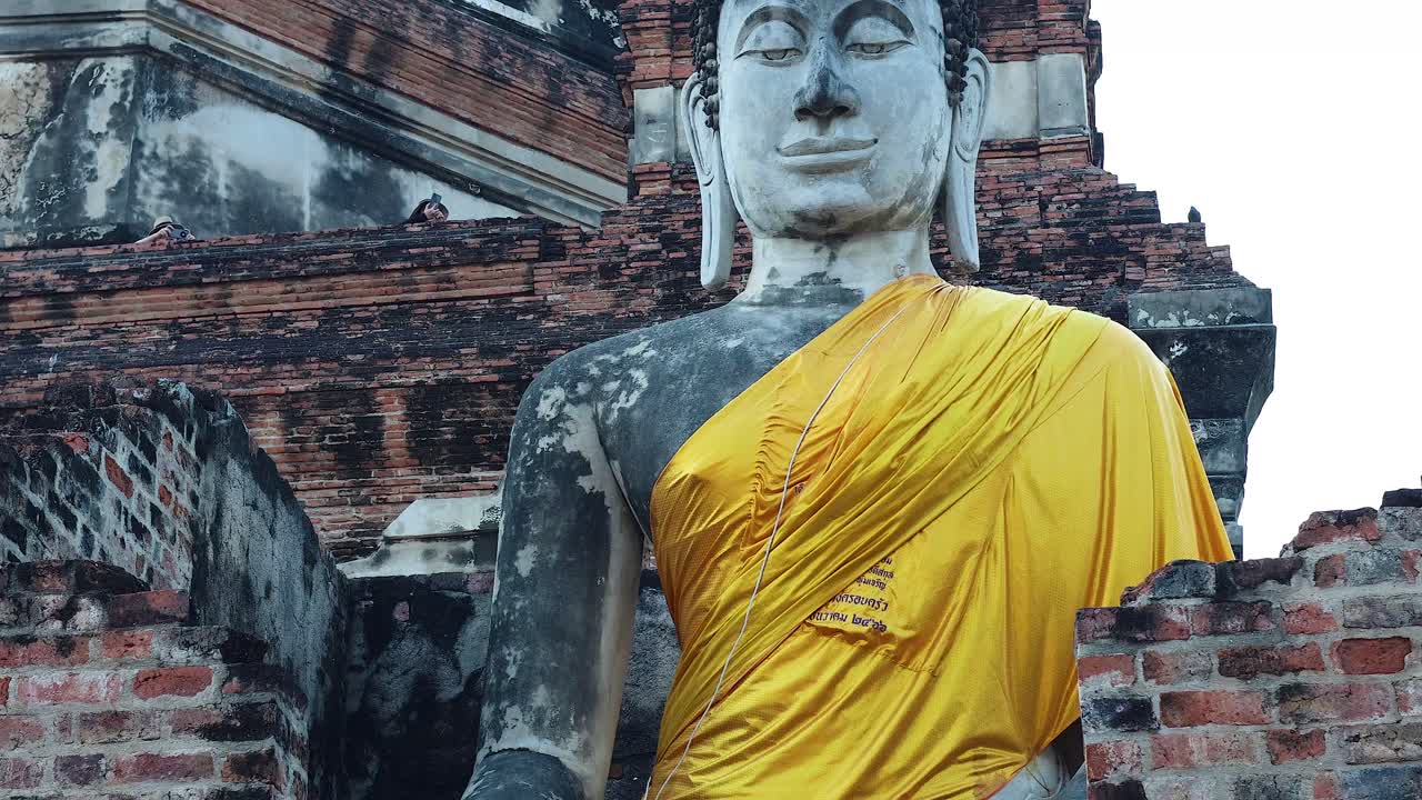 primer plano de la estatua de buda con túnica amarilla