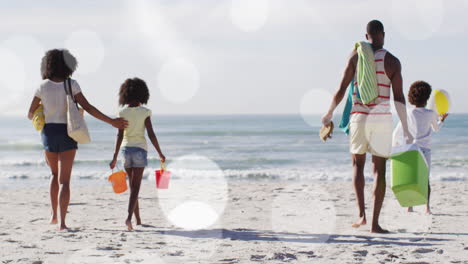 animation of spots over african american family walking on sunny beach