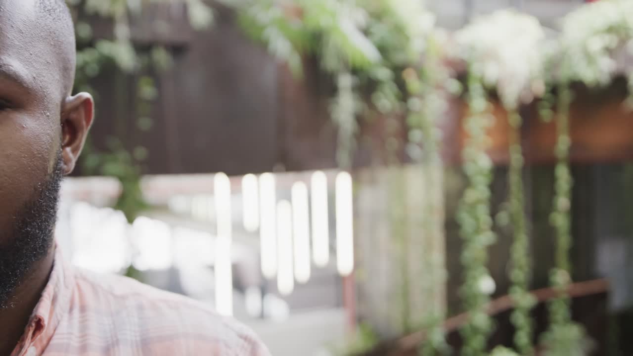 Happy african american casual businessman in foyer smiling with copy space, slow motion