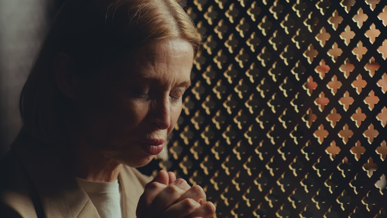 Female Parishioner Praying during Confession with Priest