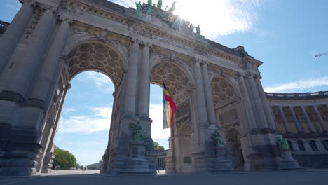 upwards angle sideways rotating shot of the cinquantennaire triumphal arc monument in brussels, belgium, on warm sunny summer day with blue skies