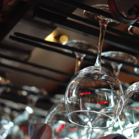 clean wine glasses prepared by bartender and hung on the bar at a restaurant or cafe. glasses prepared for a party at the bar. sqare video