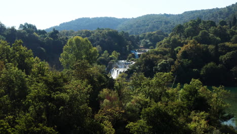 Volando-Hacia-La-Cascada-Skradinski-Buk-Con-Turistas-En-El-Puente-En-El-Parque-Nacional-Krka,-Croacia