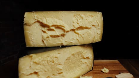 queso de cabeza dura media parmesano en tablero de madera. disparo de dolly-out