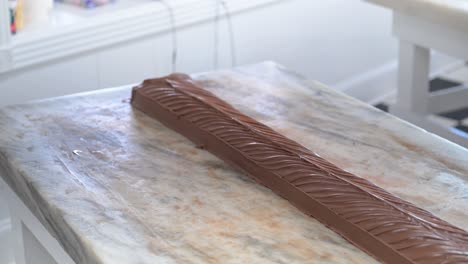 caramelo de chocolate de la isla de mackinac listo para cortar en una gran mesa de confitería de mármol