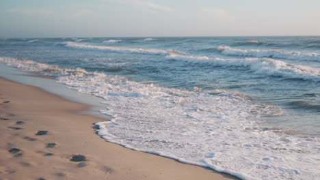 serene seashore with footprints and gentle waves