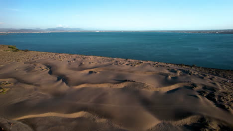 tiro de drone cuesta abajo de atletas practicando sandboard en la paz baja california sur mexico