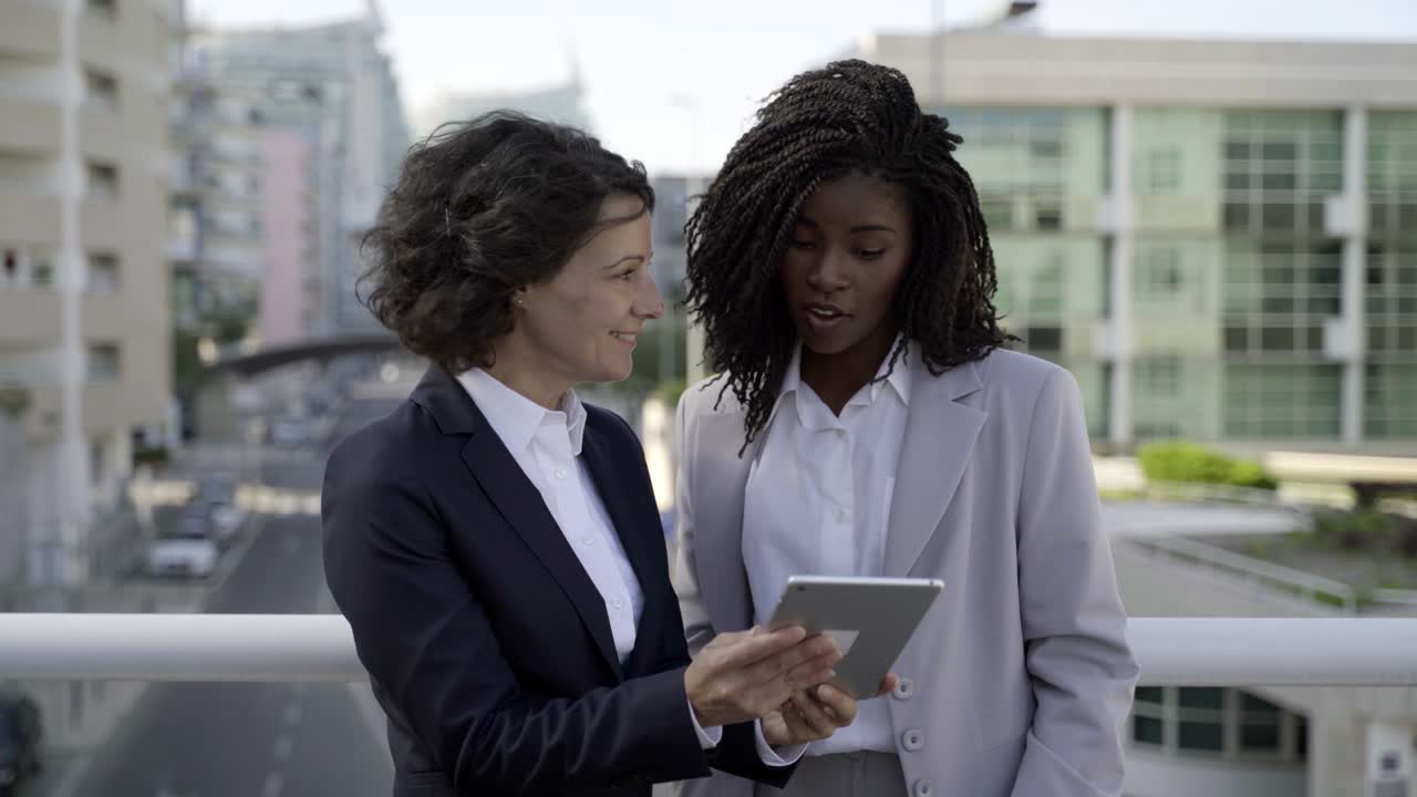 Femmes d'affaires utilisant une tablette numérique en extérieur