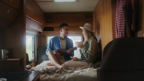 couple relaxing in rv with ukulele and coffee