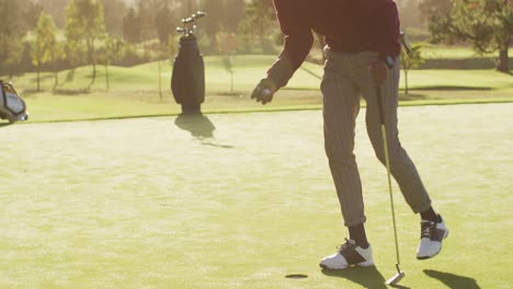 video of legs of african american man playing golf on golf field