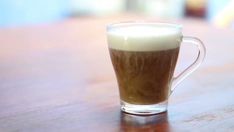 Pouring-coffee-into-a-cup-with-frothed-milk-swirls