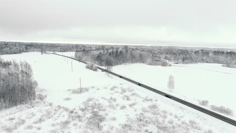 Cars-Crossing-a-remote-Country-Road-through-wild-Frozen-Field-and-forest