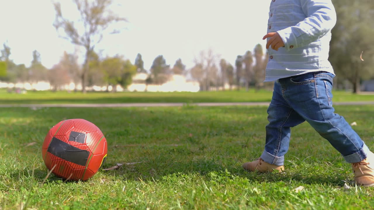 disparo medio de las piernas de los niños pequeños jugando con la pelota en el parque