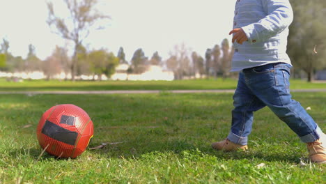 Mittlere-Aufnahme-Von-Kleinen-Jungenbeinen,-Die-Im-Park-Mit-Ball-Spielen