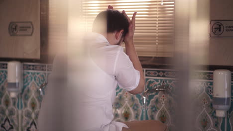 muslim man taking ablution before entering to mosque