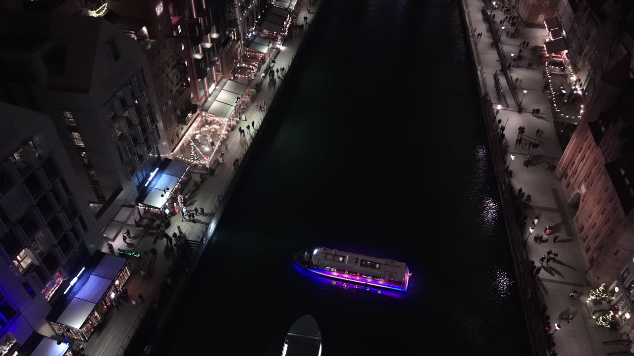 Aerial view of Gdansk's Motlawa river, boat by lit pier at Christmas
