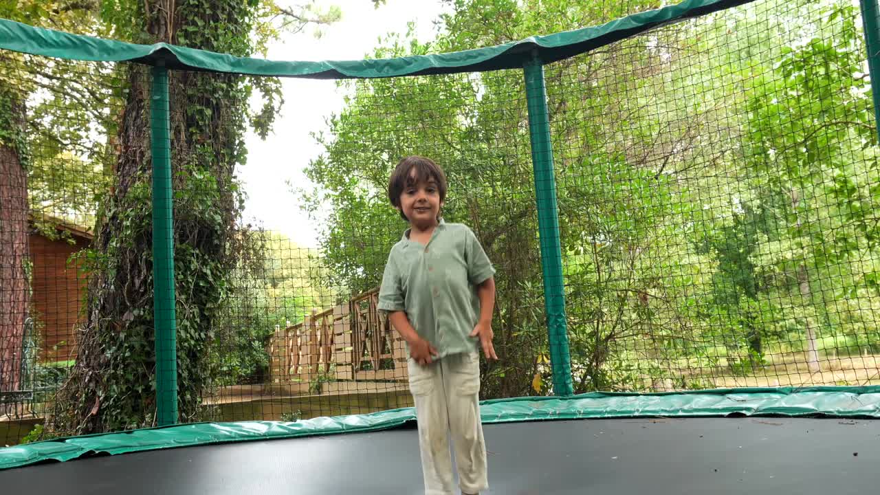 Happy Young Boy Jumping on a Trampoline Outdoors
