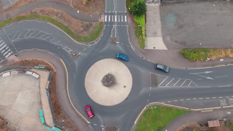 an aerial view of a roundabout with cars navigating the lanes. the clear road markings and surrounding greenery highlight efficient urban planning and traffic management