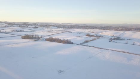 Paisaje-Invernal-Tranquilo-Con-Una-Casa-Y-Campos-Cubiertos-De-Nieve-Blanca-Hasta-El-Horizonte-En-Un-Día-Frío-Y-Brillante-En-Escocia-Durante-La-Hora-Dorada