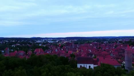 a drone rises over the ancient city in the evening aerial view red roofs of country houses