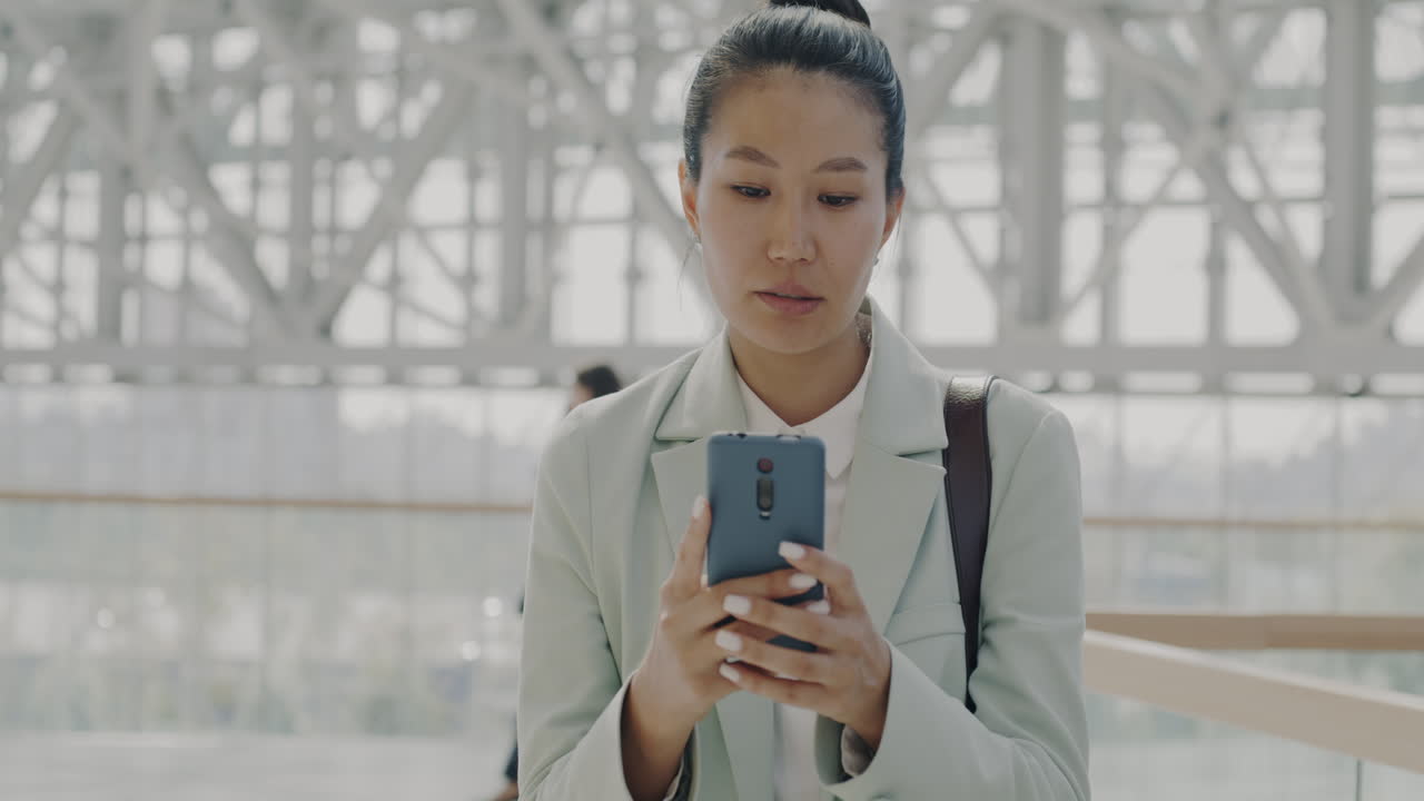 현대 건물에서 스마트폰을 사용하는 사업가