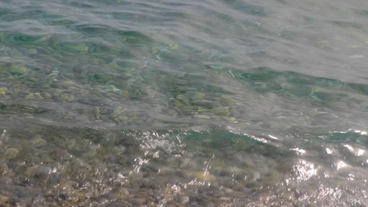 Clear water with visible pebbles on a shallow shore
