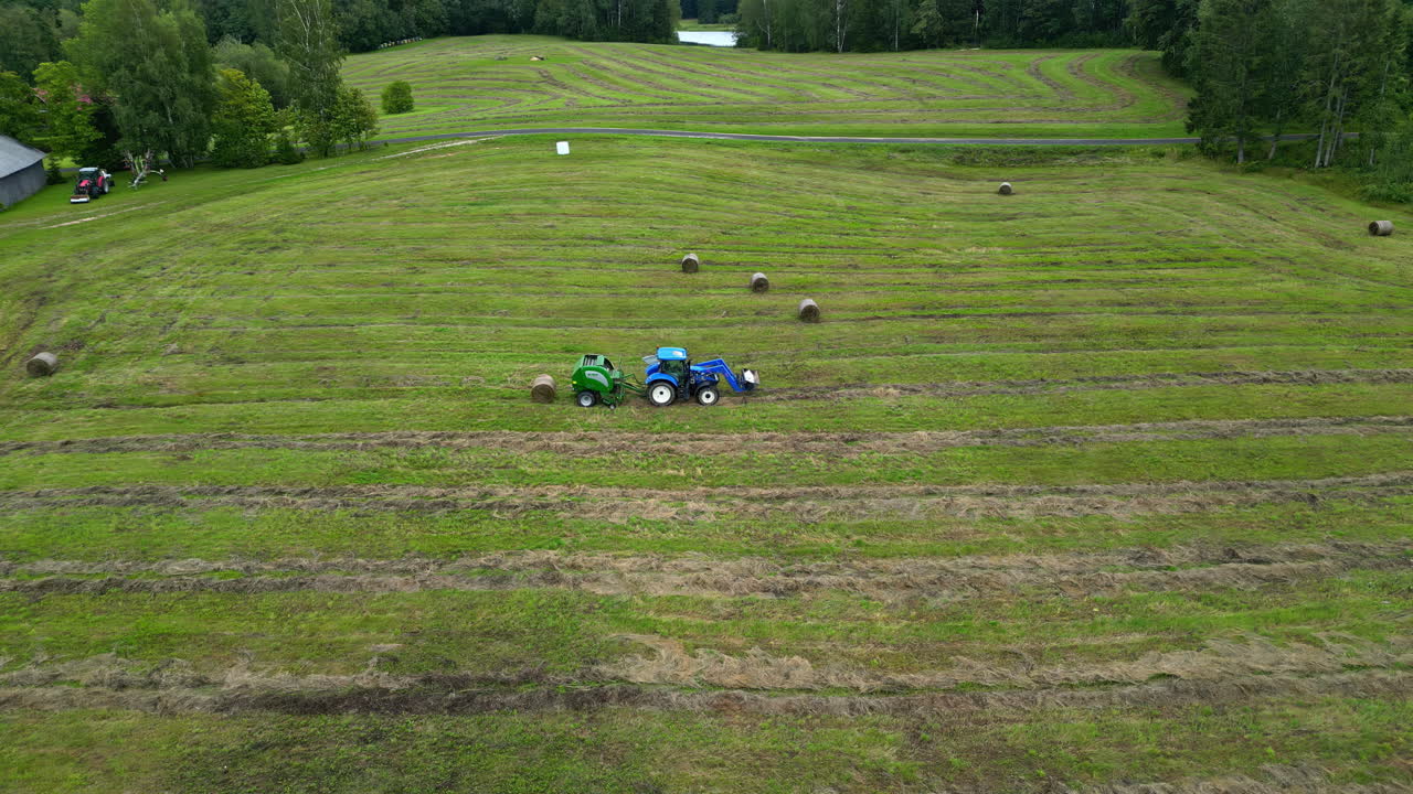 Farm homestay field with dry cut grass, aerial view farming equipment