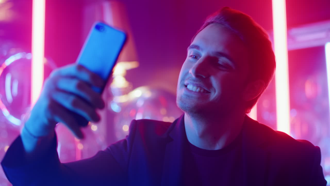 Happy man making pictures at party. Male person doing selfie in nightclub